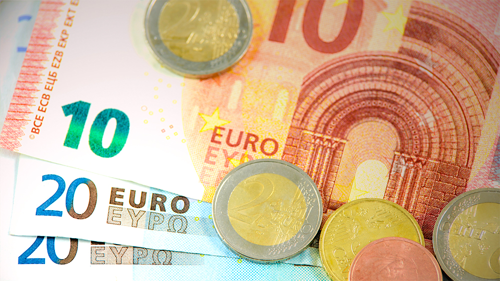 Euroscheine und Euromünzen liegen dekorativ auf dem Tisch.
