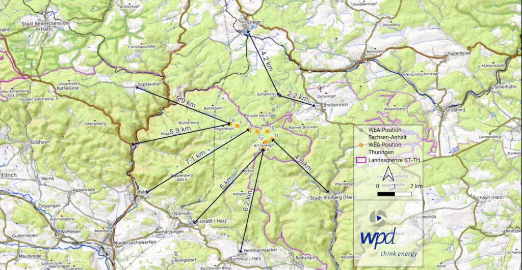 Übersichtskarte der Windparkplanungen im Südharz, erstellt von wpd. Dargestellt sind 13 geplante Windenergieanlagen (WEA) als Punkte mit Bezeichnungen (WEA_1 bis WEA_13). Schwarze Pfeile markieren die Entfernungen der Windräder zu den nächstgelegenen Ortschaften. Die Karte zeigt das umgebende Wald- und Landschaftsgebiet, Ortslagen sowie das Wegenetz.