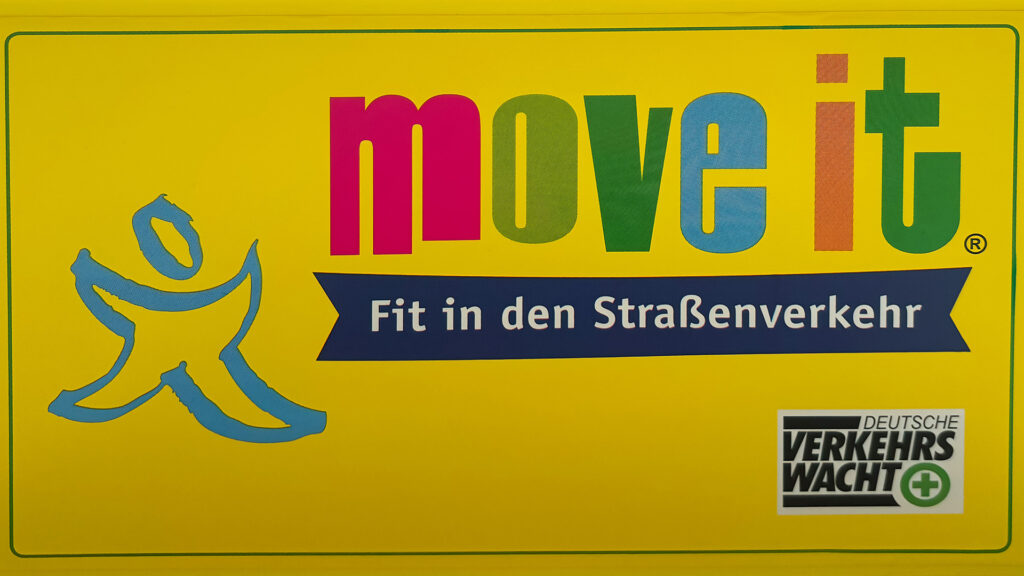 Gelbes Schild mit farbigem Move-it-Logo und Slogan ›Fit in den Straßenverkehr‹.