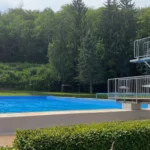 Ein Freibad am Waldrand, menschenleer, es regnet stark