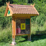 Großes Insektenhotel mit Satteldach und verschiedenen Nistmaterialien, aufgestellt am Waldrand nahe einer Streuobstwiese in Neustadt, Gemeinde Harztor.