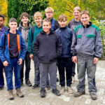 Gruppe von Schülerinnen und Schülern vor dem neuen Pavillon, lachend und zufrieden nach getaner Arbeit – Sinnbild für Teamgeist und gemeinsames Engagement.