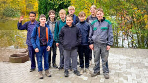 Gruppe von Schülerinnen und Schülern vor dem neuen Pavillon, lachend und zufrieden nach getaner Arbeit – Sinnbild für Teamgeist und gemeinsames Engagement.