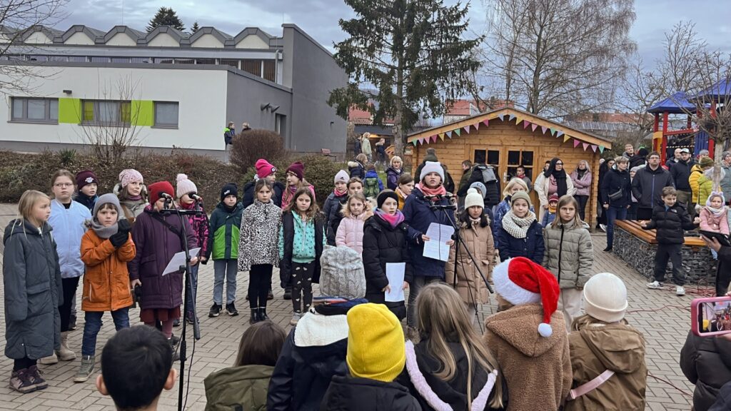 Kinder und Holzhütten bei einer Veranstaltung, Weihnachtsmarkt o.ä.