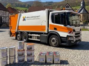 Ein Spezial-LKW zur Schadstoffsammlung steht f&uuml;r die B&uuml;rger bereit auf einem Parkplatz vor einer malerischen Harz-Kulisse mit Fachwerkh&auml;usern. KI