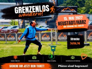 Werbeplakat Harzmarsch Maiglanz: ein begeisterter Wanderer mit ausgebreiteten Armen auf einer Wiese vor Absperrungen mit Harzmarsch-Bannern; Text mit 15. Mai 2027, Neustadt/Harz und 30 km Strecke