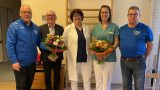 Fünf Personen stehen in einem Behandlungsraum der Klinik nebeneinander, darunter Vertreter des RSV Ilfeld e.V., die Chefärztin der Lungenklinik und die Übungsleiterin. Zwei Frauen halten Blumensträuße in den Händen.